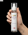 Hand holding a bottle of 'hOUSE OF PLLA Pilleo Stem Cell Mist' with a black background