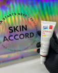 Picture of esthetician hand holding Dr.Esthe Sun Protection Mild Sunscreen at Skin Accord New Lenox, IL