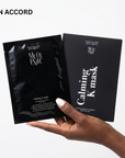 Hand holding two black Medi-Pair Calming K-mask packages against a white background.