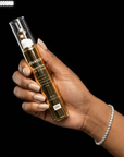 Hand holding a bottle of Hevatox Gold Eye Anti-Aging Cream against a black background