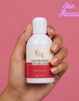 Hand holding a bottle of KRX Anti Acne Cream against a pink background with 'Skin Accord' branding.