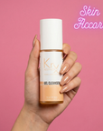 Hand holding a bottle of KRX Aesthetics Glow gel cleanser against a pink background with 'Skin Accord' text.
