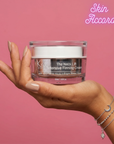 Hand holding a jar of 'KRX Aesthetics The Neck Lift' cream with 'Skin Accord' branding against a pink background.