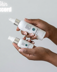 Two bottles of NeoGenesis Cleansers skincare products held by a person against a light gray background.