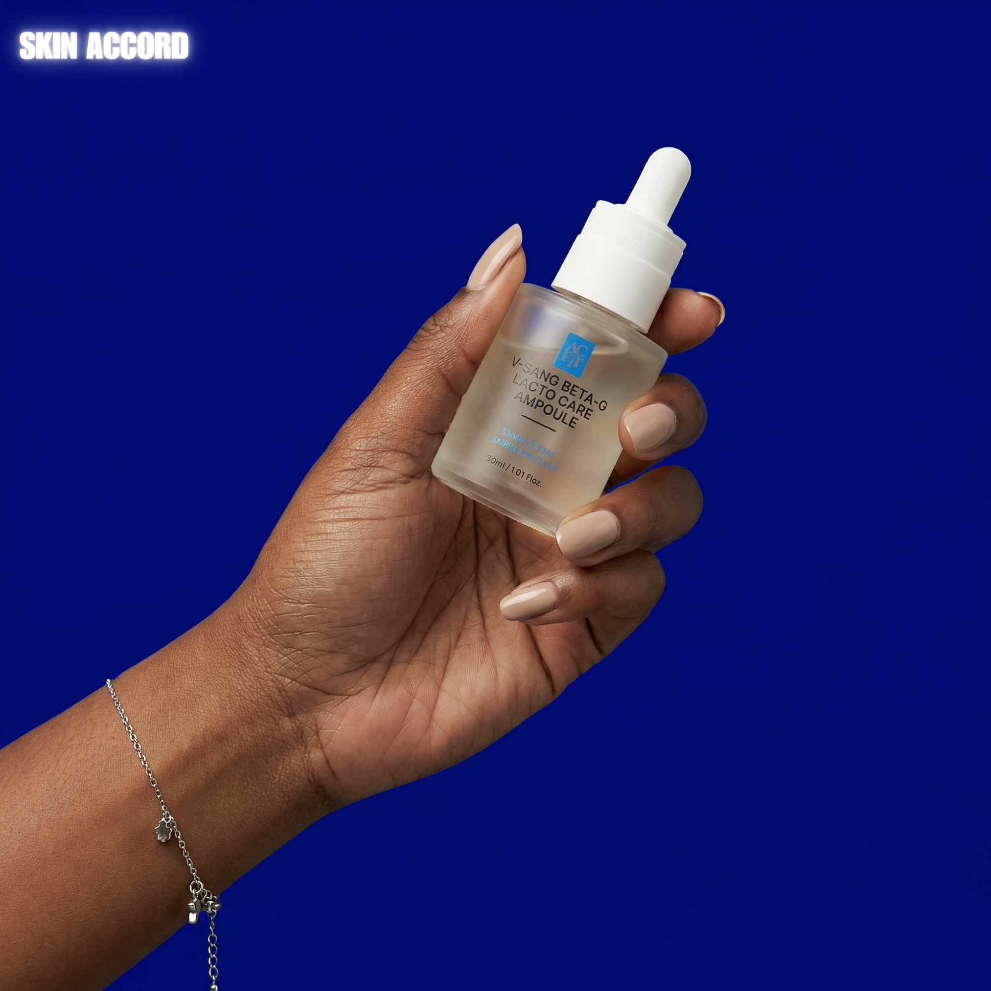 Hand holding ACFIT V-SANG Beta G LACTO CARE AMPOULE skincare dropper bottle against a blue background