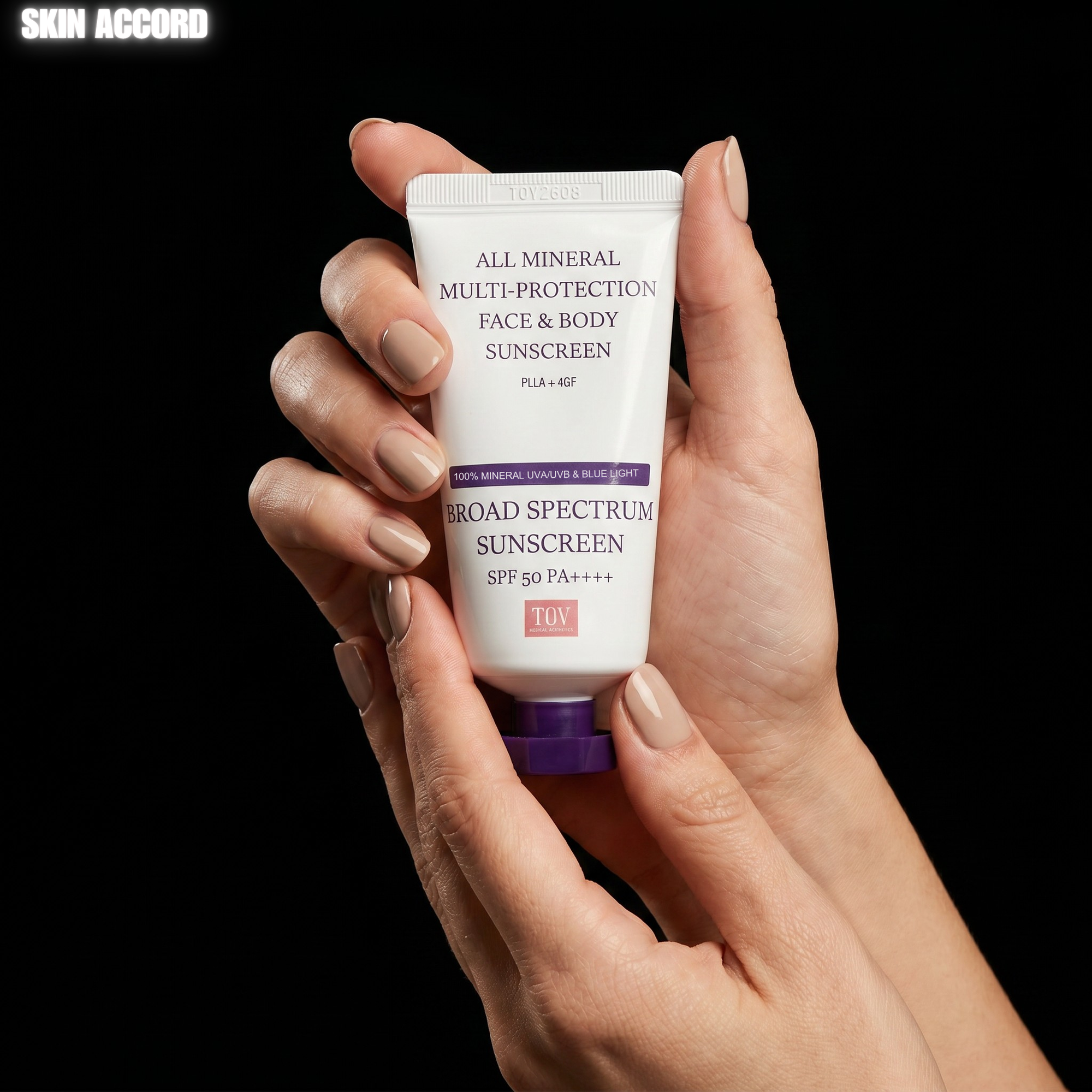 Hand holding a tube of House of PLLA All Mineral sunscreen against a black background