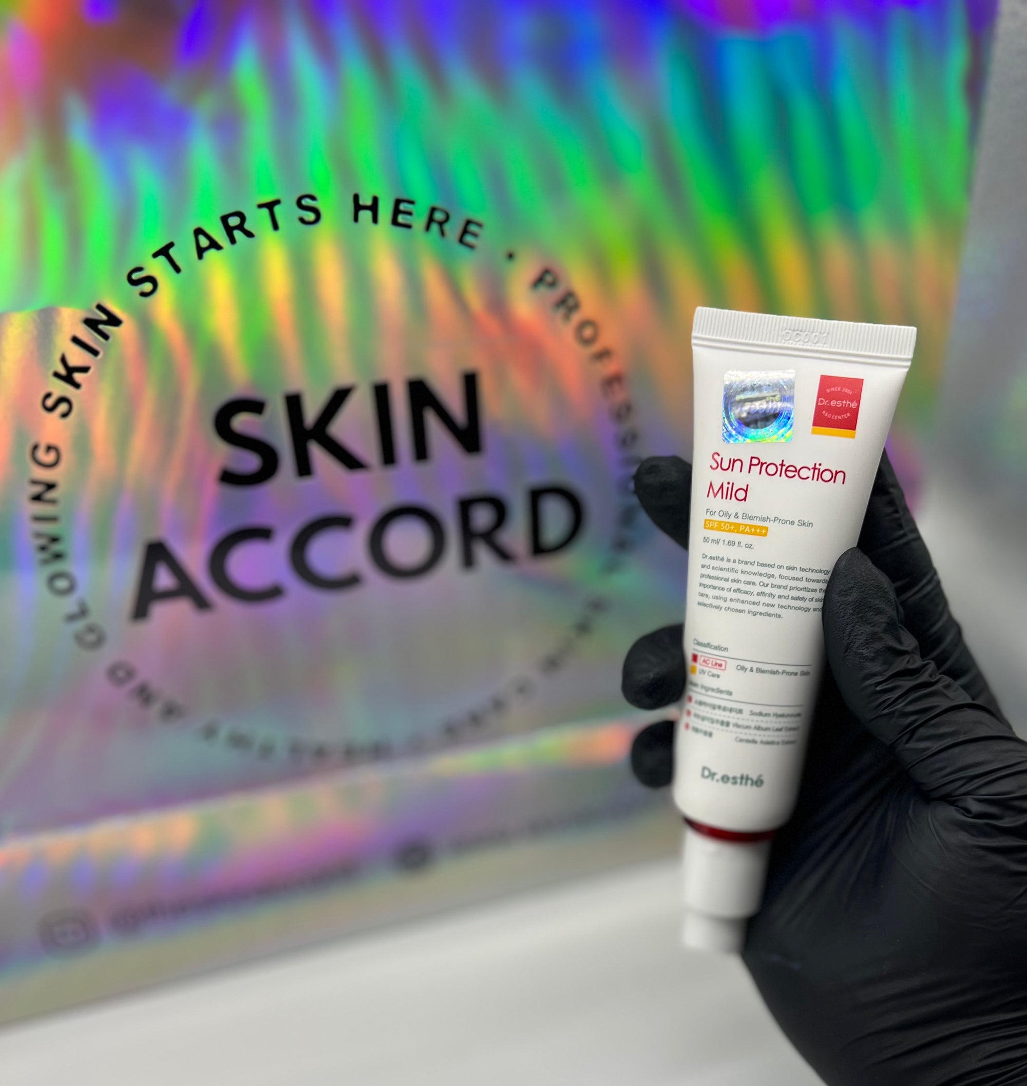 Picture of esthetician hand holding Dr.Esthe Sun Protection Mild Sunscreen at Skin Accord New Lenox, IL 