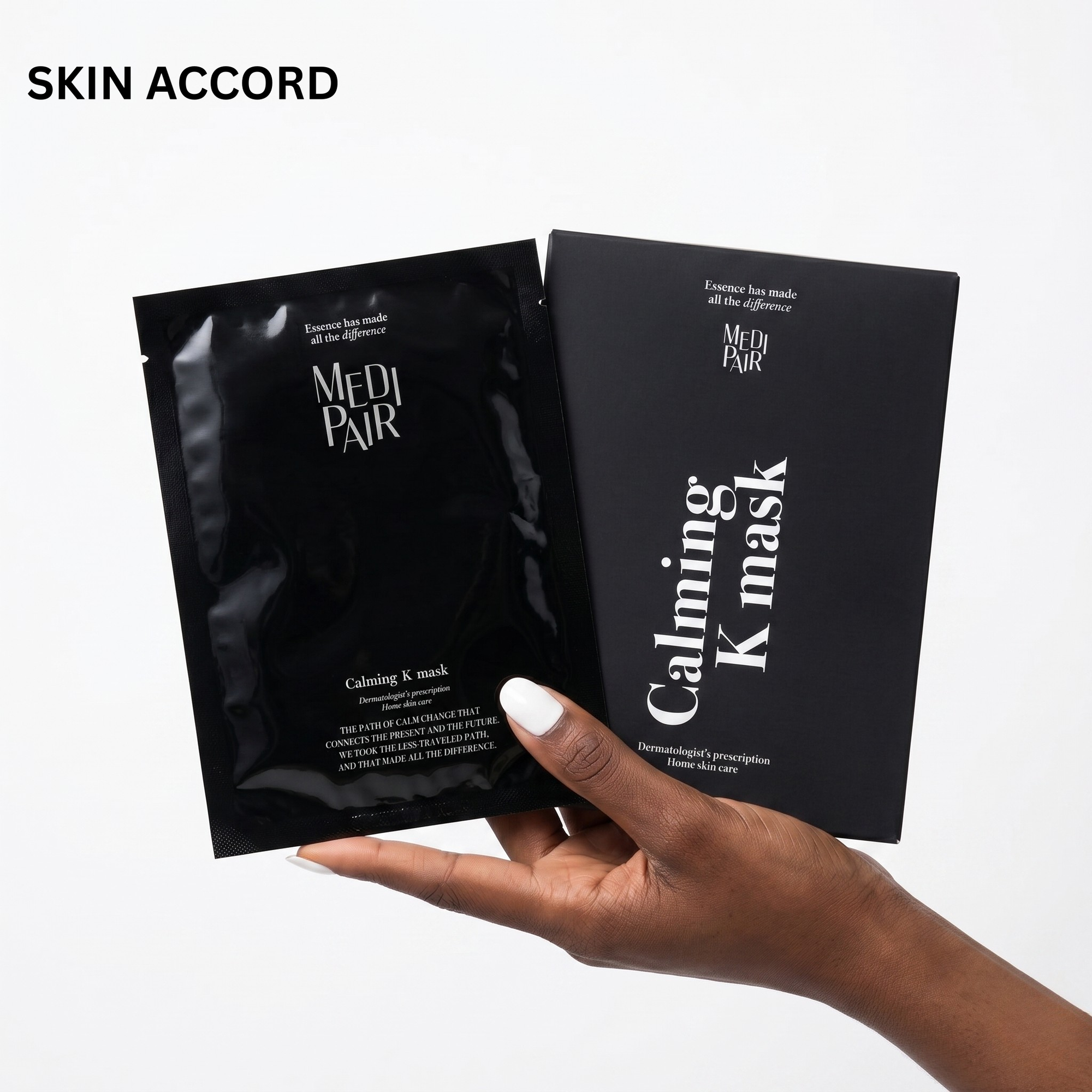 Hand holding two black Medi-Pair Calming K-mask packages against a white background.