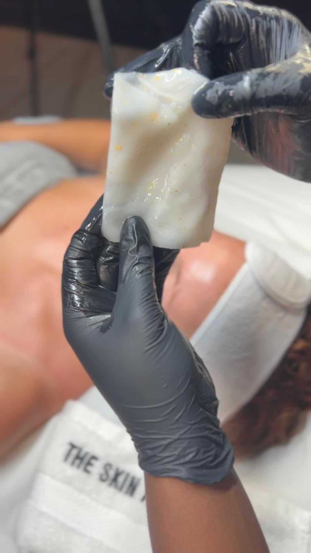 Person wearing black gloves holding a HOP 24k PLLA facial mask with visible brand name Skin Accord. 