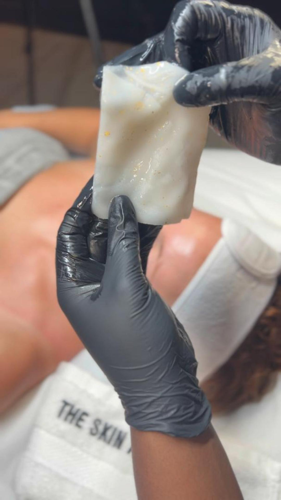 Person wearing black gloves holding a HOP 24k PLLA facial mask with visible brand name Skin Accord. 