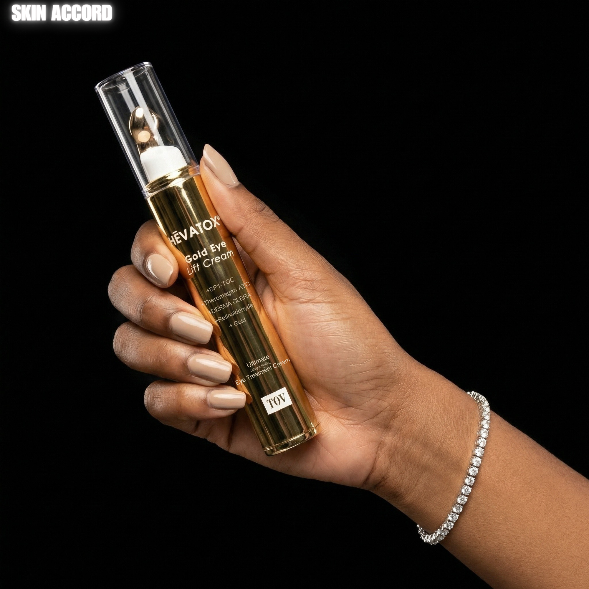 Hand holding a bottle of Hevatox Gold Eye Anti-Aging Cream against a black background