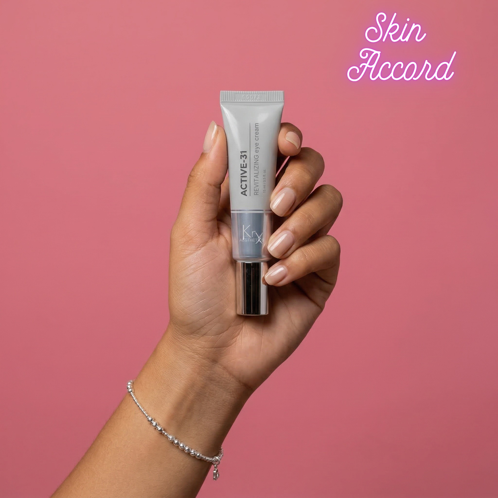 Hand holding KRX Aesthetics Active 31 eye cream with 'Skin Accord' branding on a pink background