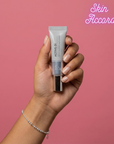 Hand holding KRX Aesthetics Active 31 eye cream with 'Skin Accord' branding on a pink background