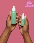 Two hands holding KRX Cica Recovery Serum bottles with a pink background and 'Skin Accord' branding.