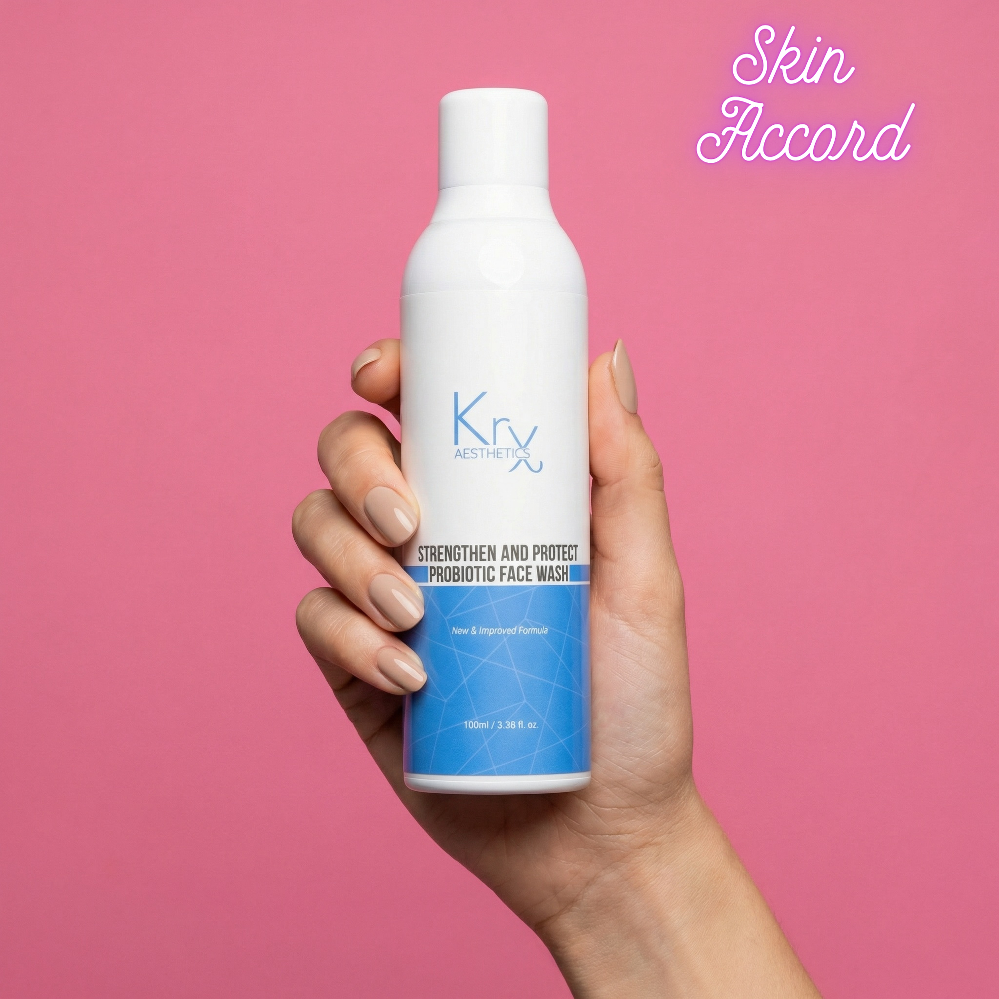 Hand holding a bottle of KRX Probiotic Face Wash against a pink background