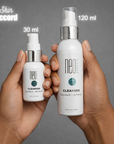 Two bottles of Neo Cleanser held by hands against a gray background