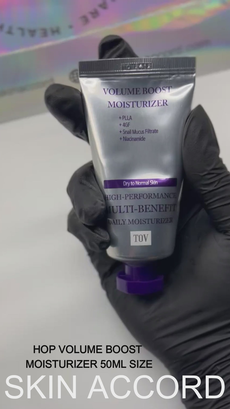 A black gloved hand holding HOP Volume Boost Moisturizer  at Skin Accord in New Lenox, IL 