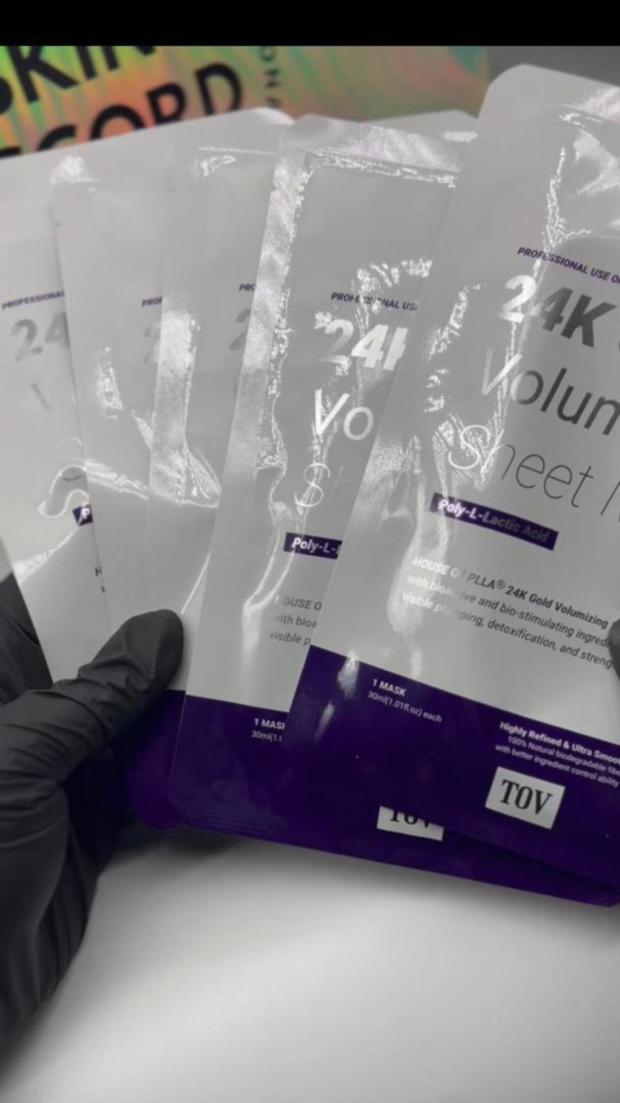 Picture of esthetician black gloved hand holding House of PLLA HOP 24k Gold Volumizing Sheet Mask at Skin Accord in New Lenox, IL 
